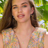 Woman wearing a floral dress with a necklace in a tropical setting